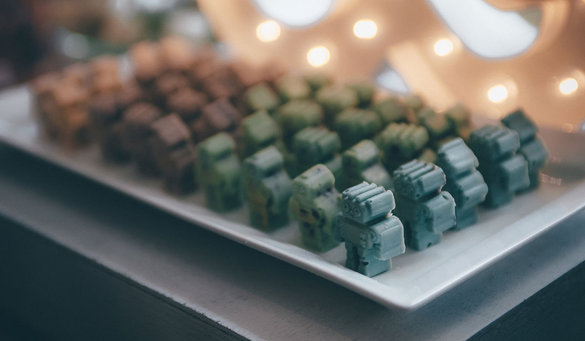 Colour coordinated robots lined up in rows and columns on a long plate